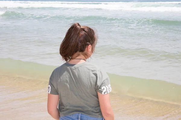 バックビューの砂のビーチの少女夏リラックスした波の地平線を見て — ストック写真