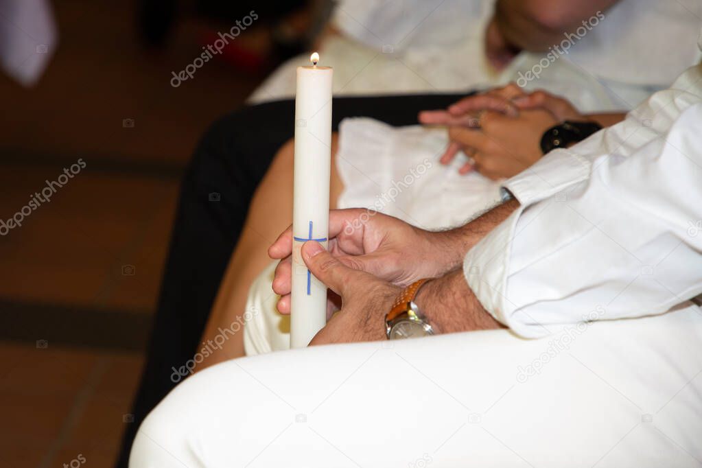 Baptism holy candle at a christian christening of a new born baby during infant ceremony in Church