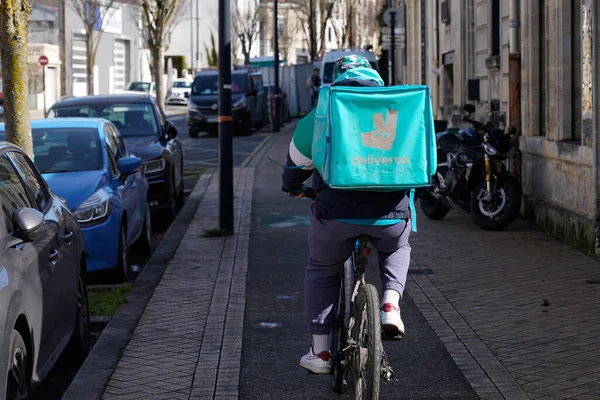 Bordeaux, Aquitaine France - 03 07 2022: Arkasında sırt çantası olan bisikletli yeşil motosikletli kurye üzerinde teslimat logosu ve metin imzası