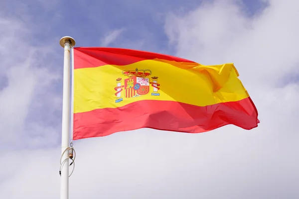 西班牙国旗在多云的天空中飘扬 — 图库照片