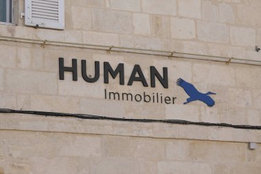 Bordeaux, Aquitaine France - 06: 15 2022: Insan hareketsiz hale getirici mavi kuş logosu imzaladı ve Wall Facade şirketindeki emlak mağazası komisyoncusu için metin