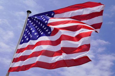 Amerikan bayrağı. Ulusal eyaletler bayrağını rüzgârda salladı. Mavi bulut gökyüzüyle bizi ezdi.