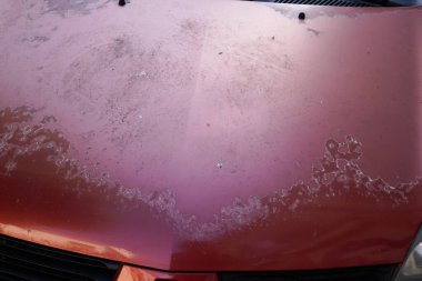 Araba kırmızısı, soyulan boyayı kullanmış. Kaputun üzerindeki pembe çizik. Güneş ay doğduğunda eskimiş.