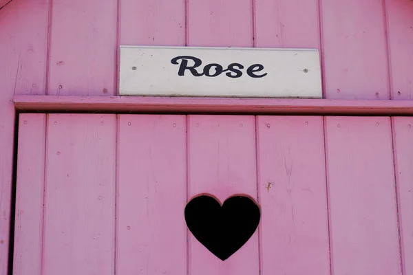Różowe Drewniane Drzwi Tło Wyciętym Sercem Napisany Kwiat Róży Oznacza — Zdjęcie stockowe