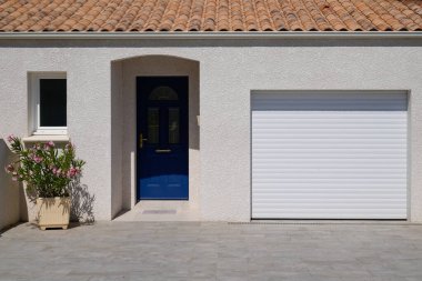 Çağdaş beyaz garaj kapısı olan modern ev cephesi