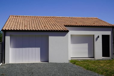 Garaj kapısı ve girişi olan modern bir banliyö evi.