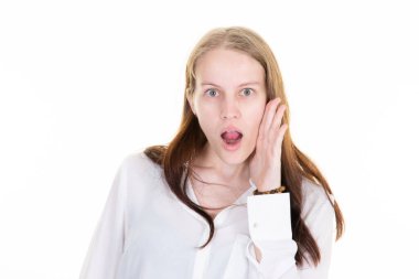 Güzel bir kadın beyaz arka planda şok edici bir ifade sergiliyor.