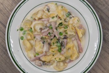 Tortellini alla piemontese tavuklu makarna ve kremalı mantar sosu çok doyurucu bir İtalyan yemeği için servis ediliyor..