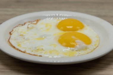 İki yumurtalı omlet ve üstünde parlak sarı sarısı olan bir kahvaltı..