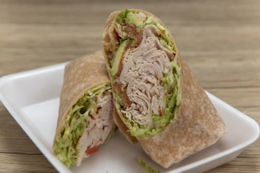 Taze malzemelerden yapılmış hindi, domuz pastırması ve avokado dürümü sağlıklı bir diyet için..