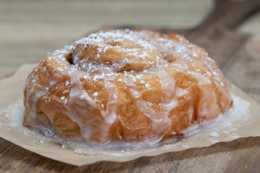 Bu tarçınlı rulonun üzerine erimiş krema. Fırından taze fırında pişirilmiş. Tatlı bir tatlı kahvaltısı olarak..