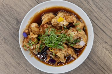 Keskin bir sosla kızartılmış karnabahar tabağının tepesinde..