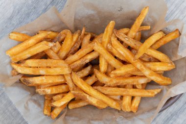 Baştan çıkarıcı patates kızartması sepetinin yukarıdan görünüşü. Kızartmadan sıcak ve yemeye hazır..