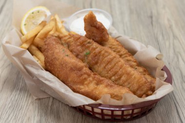 Ekmek arası balık kroket ve patates kızartması, iştahı doyurmak için sepette birleşir..