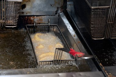 Lokanta mutfağında yemek pişirirken kalamar halkaları kızgın yağda cızırdar..