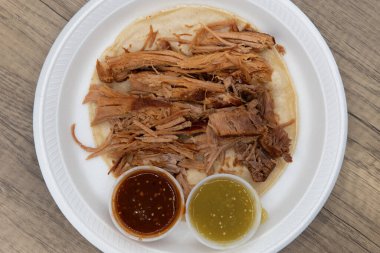 Bu taco yemeği için kırmızı ve yeşil salsa soslu tortilla üzerine bol miktarda Carnitas domuz eti..