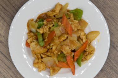 Tabakta uzun bir yığın oluşturan karışık sebzeli baharatlı tavuk manzarası..