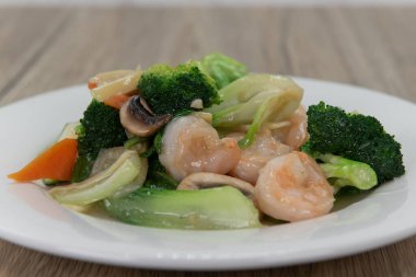 Lezzetli Çin mutfağı için tereyağı sosunda yüzen karides ve karışık sebzeler..