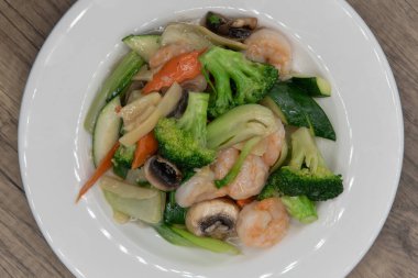 Lezzetli Çin mutfağı için tereyağlı sosta yüzen karides ve karışık sebzelerin genel manzarası.