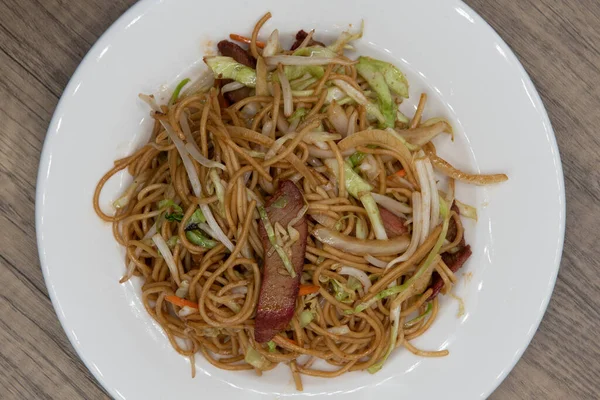 Barbekü domuz eti, chow mein ve sağlıklı erişte manzarası tüm tabağı lezzetli bir Çin yemeği ile dolduruyor..