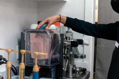 Blender kapağını kapalı tutarken buzlu içecek için boba smoothie malzemelerini karıştırıyorum..