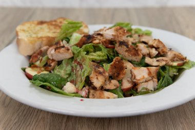 Creative recipe of apple pecan chicken salad served in a generous bowl with garlic toast for a delicious meal to eat.