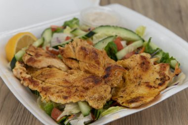 Izgara tavuk salatası siparişini tamamen köpük kutusunu doldurarak ver..