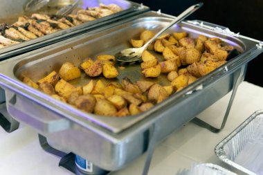 Büfe masasında konuklar için baharatlı ve kızarmış patates tabağı var..