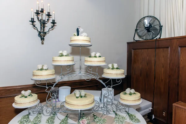 Wedding cake displayed on an arch of tiers so there is plenty of the sweet dessert for all to eat.