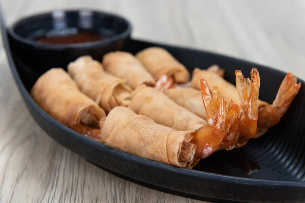 Crispy shrimp egg roll for a Vietnamese meal appetizer served in a boat.