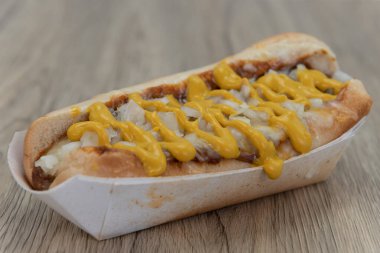 Hardal şeritleri soğan kokan geleneksel acılı sosisli sandviçi süslüyor..