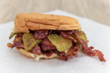 Cazip kalori dolu pastırmalı sandviç dilimlenmiş turşuyla süslenmiş ve yemeye hazır..