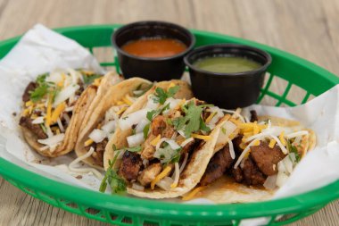 Fast food sepetinde servis edilen tavuk, biftek ve domuz eti de dahil olmak üzere bir sürü taco..