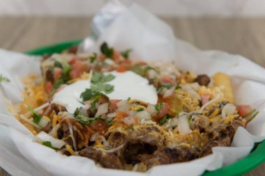 Fast food sepetinde servis edilen Asya usulü patates kızartmalarıyla dolu bir yemek..