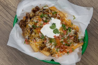 Fast food sepetinde servis edilen Asya usulü patates kızartmalarıyla dolu yüklenmiş yemek manzarası..