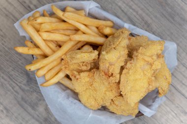 Lezzetli bir fast food yemeği için bir sepet kızarmış balık ve patates kızartması..