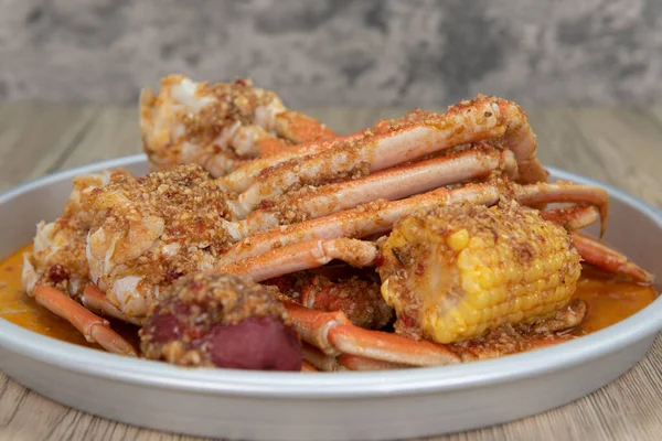 Delicious buttery seasoned snow crab legs with corn on the cob for a great seafood boil.