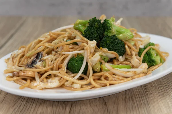 Bol soslu bol sebzeli şehriye ve Çin yemeği için tabağın üstüne istiflenmiş..