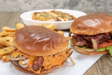 Barbekü burger ve acılı peynirin önünde erimiş peynirli burger yemek için zor bir seçim..