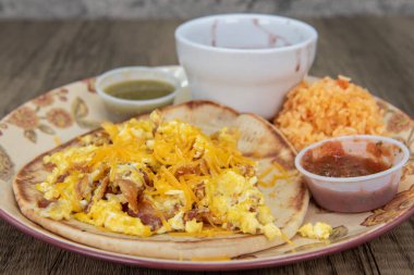 Kalın ev yapımı tortilla kahvaltıda içinde erimiş peynir, kişniş ve salsa sosu bulunan taco tutar..