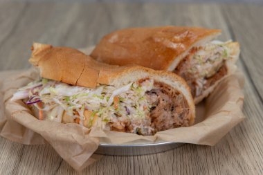 Cezbedici BBQ taze pişmiş İtalyan rulosunda servis edilen marul ve turşuyla domuz sandviçi çekti..