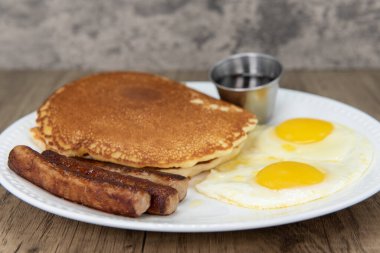 Standard American breakfast consisting of pancakes, fried eggs, and sausage will ensure that the belly will be full.