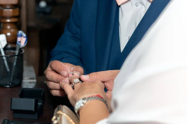 Groom placing ring on finger of the bride during the civil wedding ceremony of marriage.