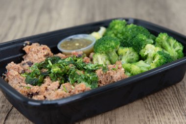 Take out order of ground turkey with rice and broccoli is conveniently packed in a microwavable container.