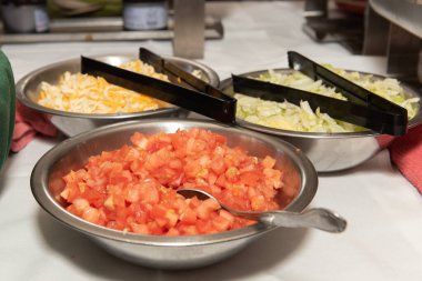 Açık büfe sırasındaki taco yapımında pico de gallo ve maşayla birlikte kaselerdeki diğer dolgular var..