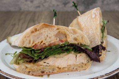 Biberiyeli tavuk göğsü sandviçi. Taze pişmiş ciabatta ekmeği üzerine savoy yeşili ve provolone peyniri..