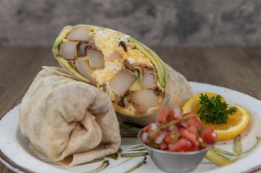 Kahvaltı dürümü omlet, avokado ve patateslerin karışımını göstermek için ikiye bölündü..