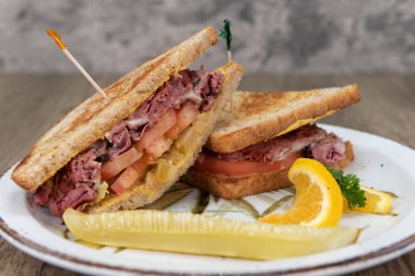 Kızarmış pastırmalı sandviç, dışı çıtır çıtır, içi domates ve turşu dolu..