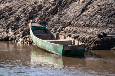 Sakin nehrin kıyısında kumlu bir kano.
