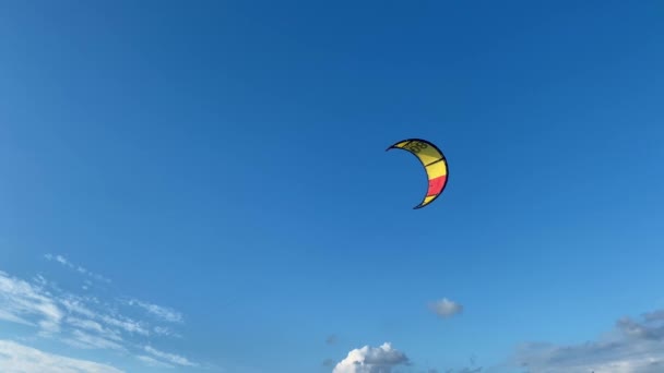 波の中でカイトサーファーと海の風景 カラフルなカイトサーフィン帆は曇り空を飛ぶ — ストック動画
